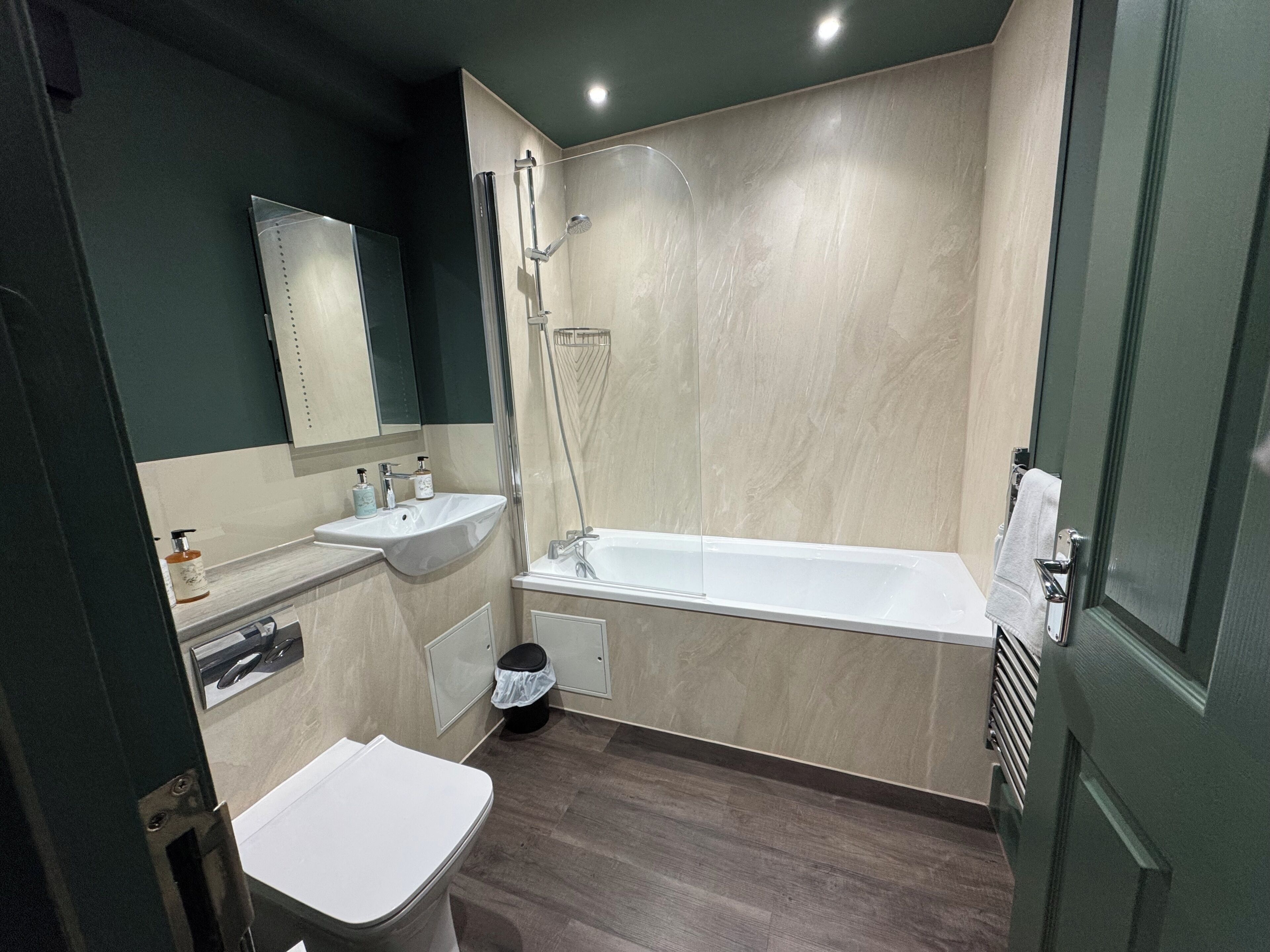 A bathroom with a sink, mirror, shower, and toilet.
