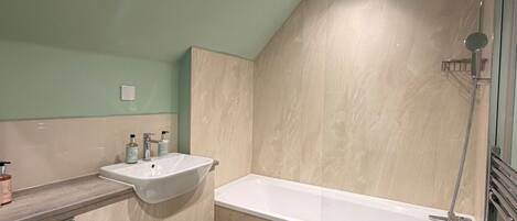 A bathroom with a sink, toilet, bathtub, and shower.