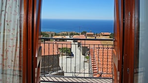 A balcony with a view of the sea and houses. - Vrachos Villas (Agios Vasileios)