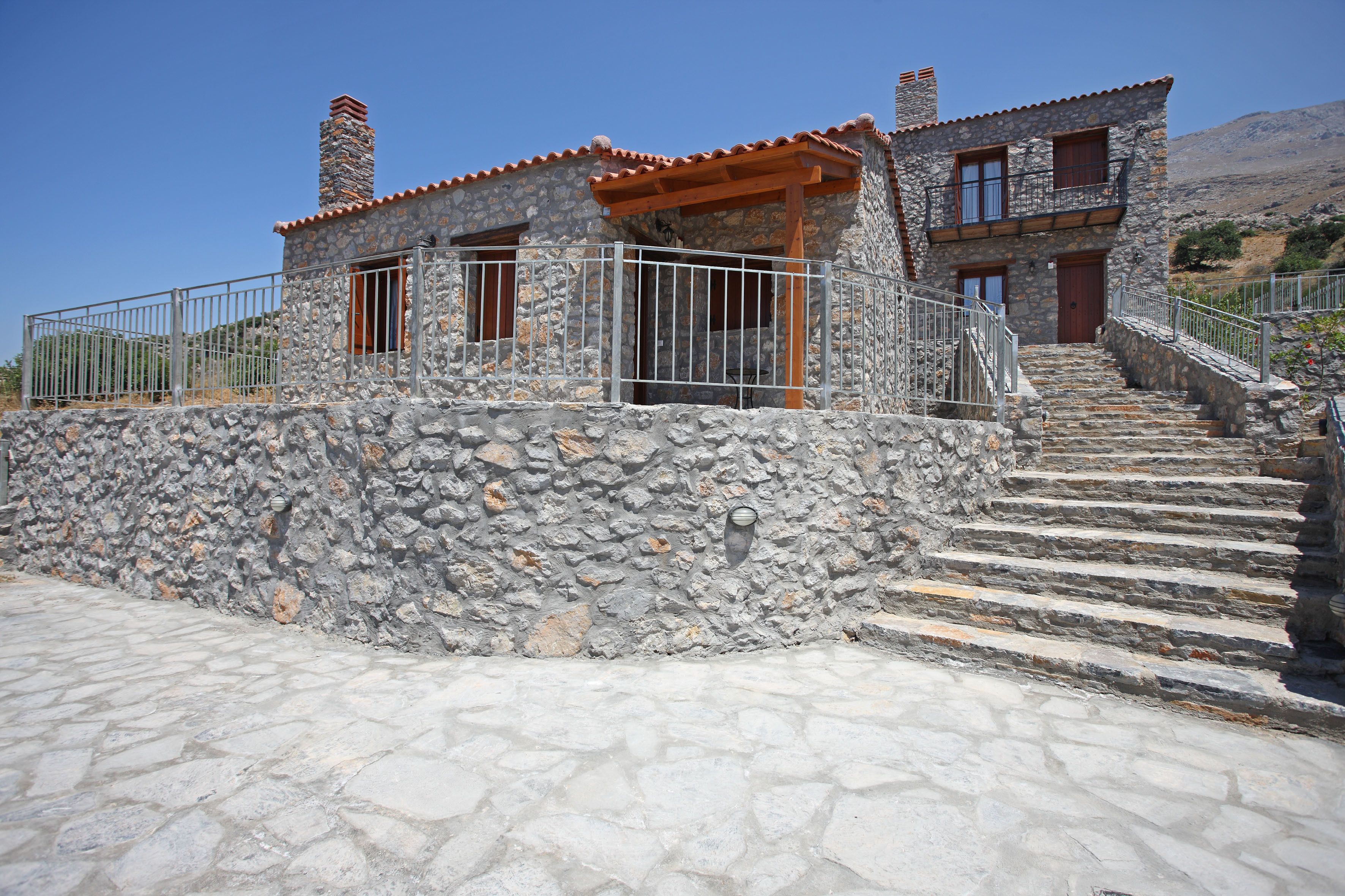 A stone house with a stone staircase leading to the entrance.