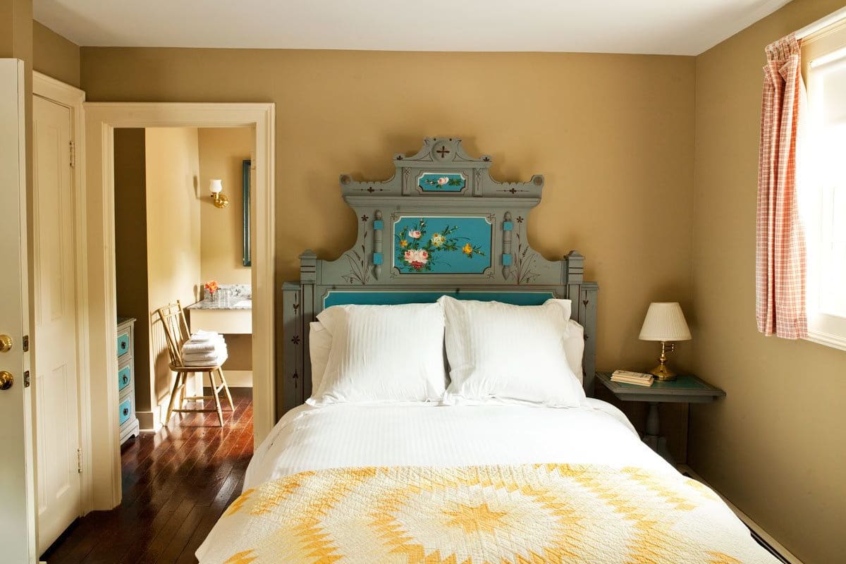 A bedroom with a bed, a nightstand, a chair, and a dresser.