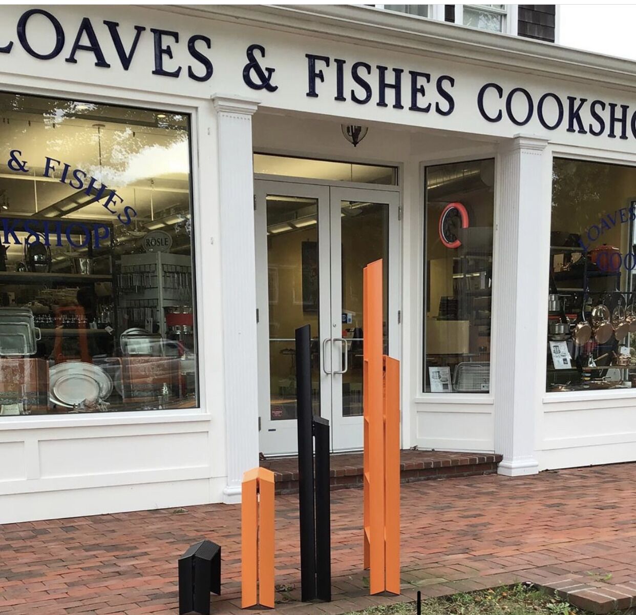 Una fachada de tienda con un letrero que dice 'Loaves & Fishes Cookshop'.