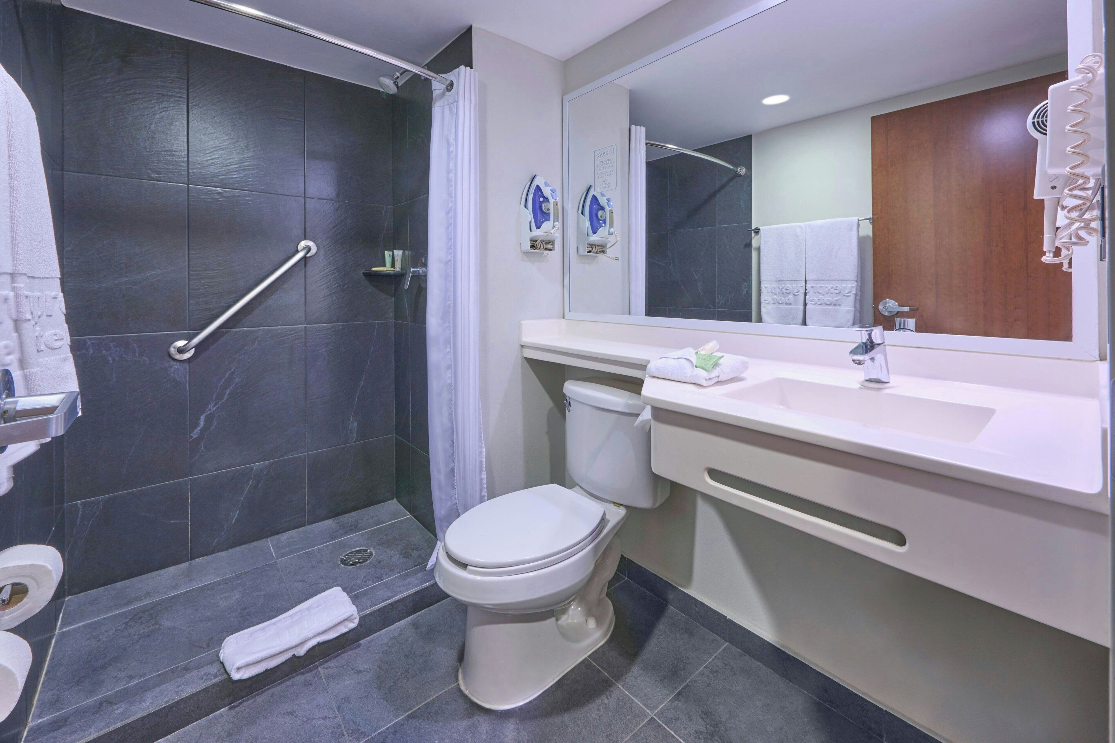 Un baño moderno con ducha, inodoro y lavamanos.