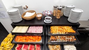 Un bufé con una variedad de alimentos, incluyendo frutas, carnes y postres.