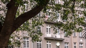 Un edificio con un cartel que dice "HOTEL AMERICA" y un balcón con barandilla.