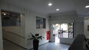Un vestíbulo moderno con una escalera, una planta en maceta y un mostrador de recepción.