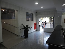 Una hall moderna con una scala, una pianta in vaso e una scrivania della reception.