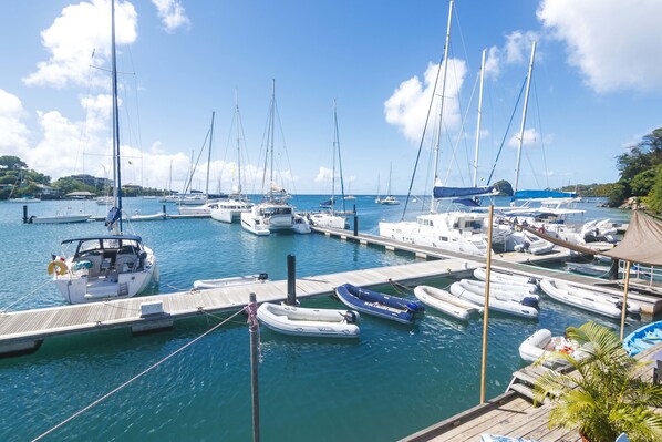 A marina with various boats docked at wooden piers.