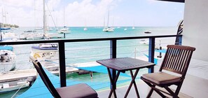 A balcony with a view of a marina, featuring boats and calm waters.