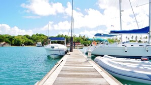 A wooden dock with boats moored at the end.