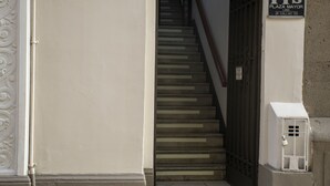 A staircase leading to a door with a sign reading "Plaza Mayor" and "Jr. Callao 125". - Plaza Mayor Lima (Lima)