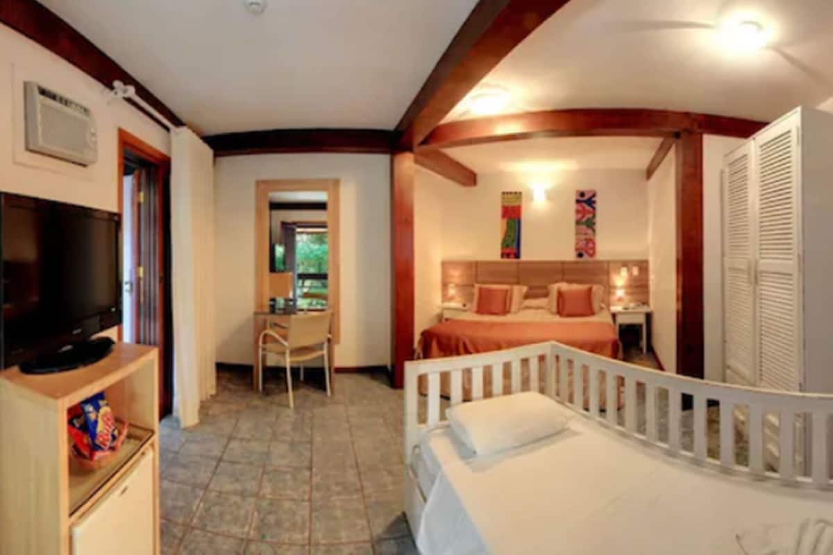 Une chambre à coucher avec un lit, un bureau et un téléviseur.