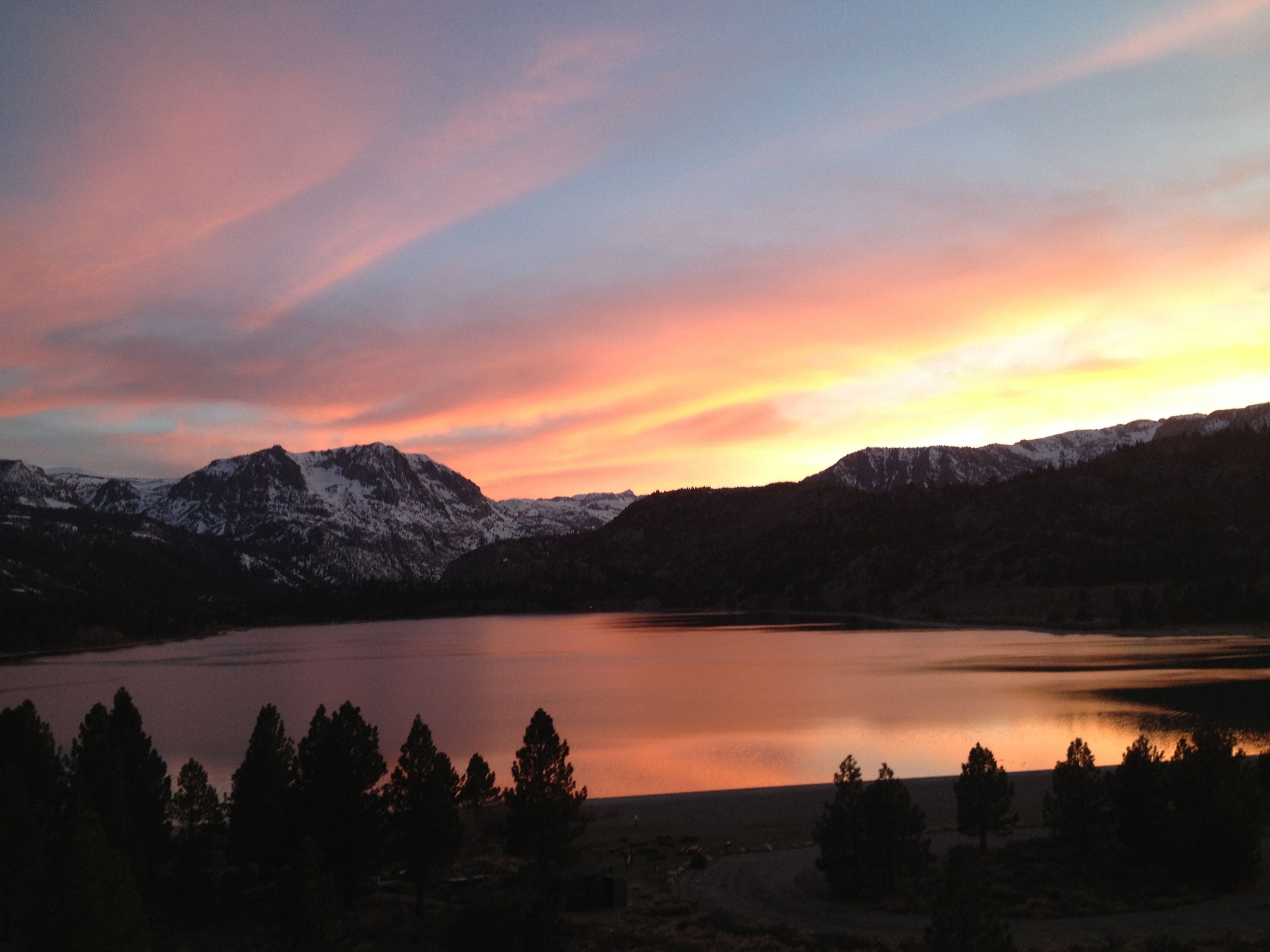 A mountain landscape with a lake and snow-capped peaks.