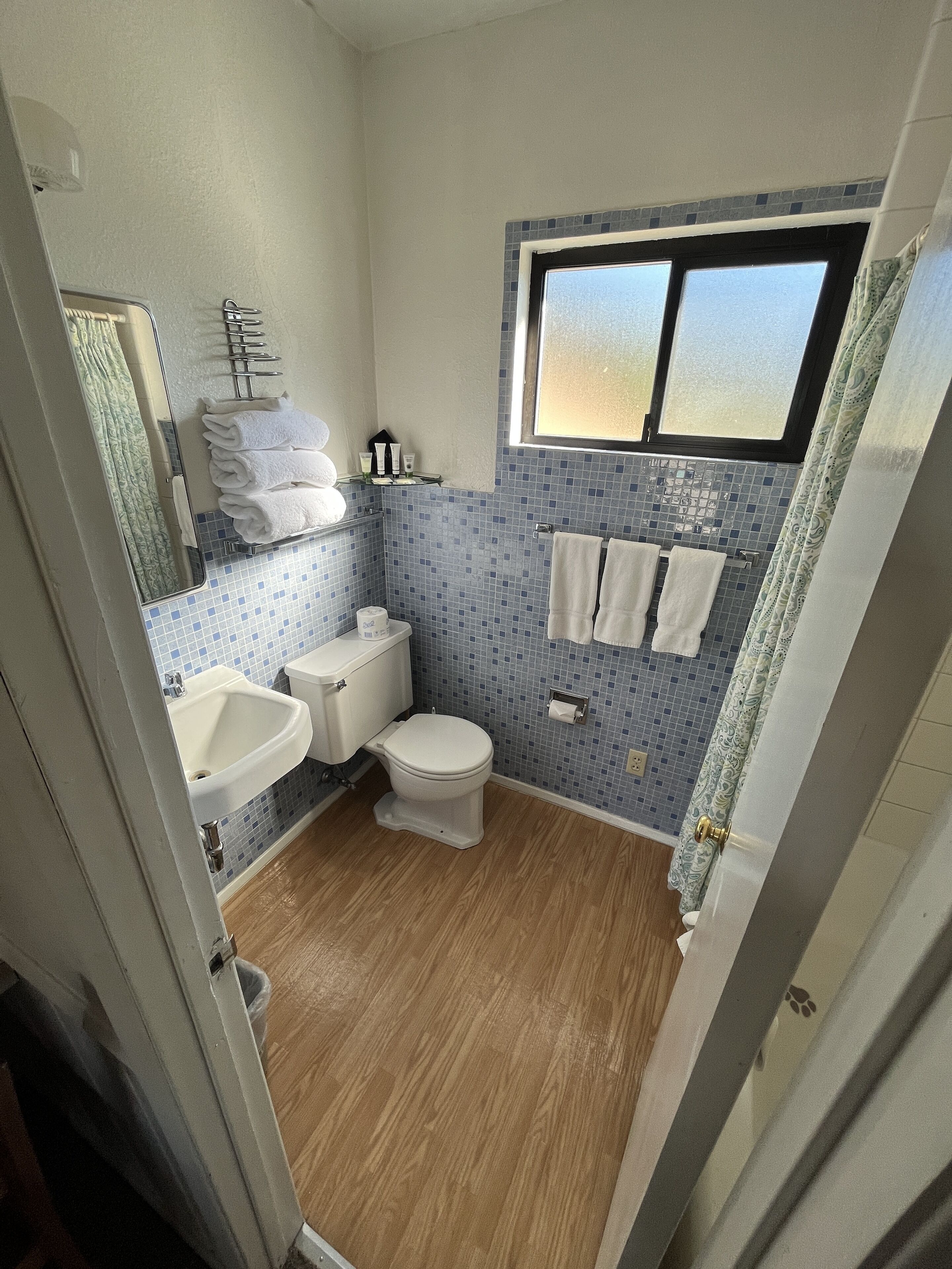 Une petite salle de bain comprenant des toilettes, un lavabo et une fenêtre.