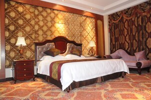 A bedroom with a large bed, a nightstand, a dresser, and a chair.