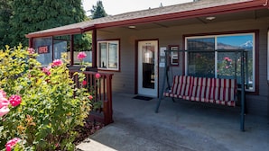 A building with a porch, a bench, and a sign that says "OFFICE".