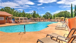 A swimming pool with lounge chairs and a covered area, surrounded by trees and a clear sky. - Sedona Pines Resort (Sedona)
