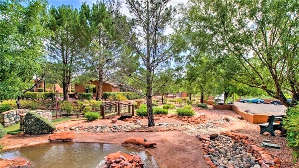 A landscaped garden with a pond, pathways, and a wooden bridge. - Sedona Pines Resort (Sedona)