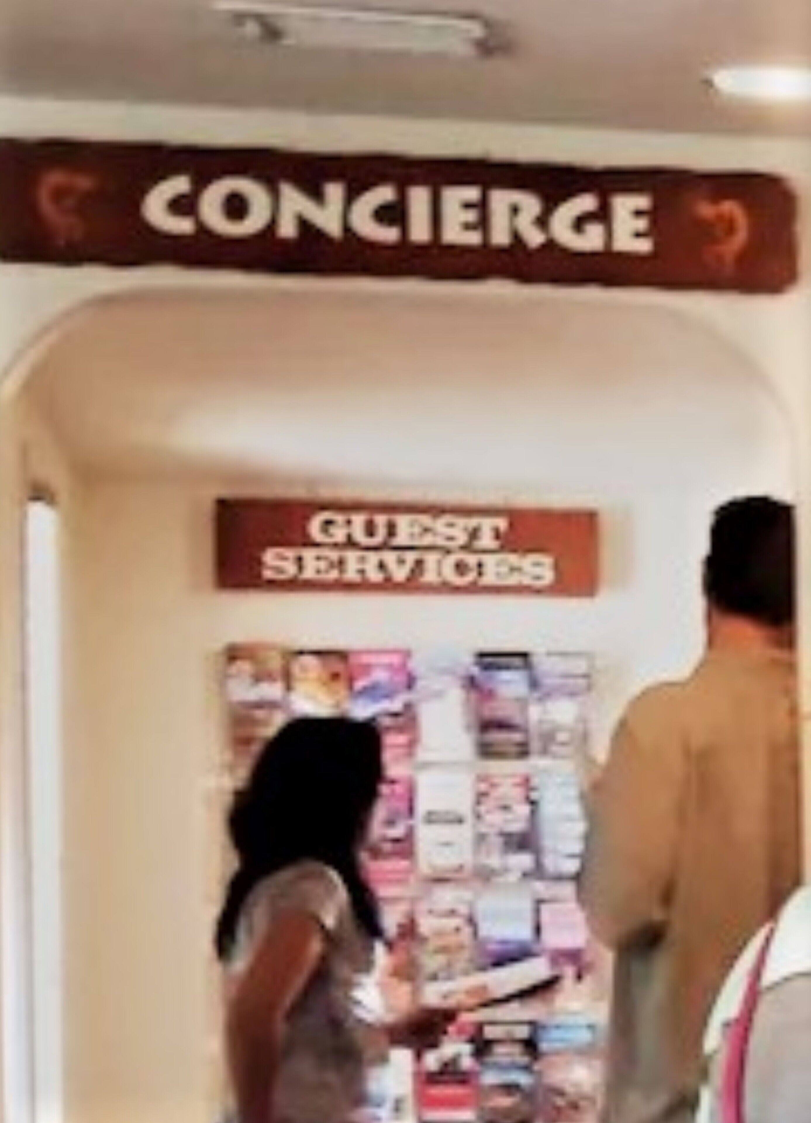 A concierge area with a sign above a guest services counter.