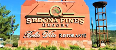 A sign for Sedona Pines Resort with Bella Vita Restaurante.