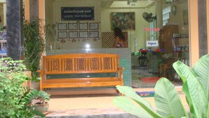A massage parlor with a wooden bench outside, a 'Wellcome' sign, and a 'Please take your shoes' notice. - Sandee Bungalows (Ko Pha-ngan)
