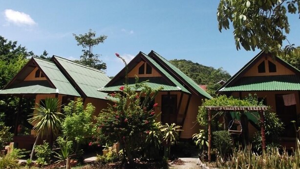 A row of cabins with green roofs, surrounded by lush greenery and a clear sky. - Sandee Bungalows (Ko Pha-ngan)