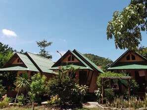 A row of cabins with green roofs, surrounded by lush greenery and a clear sky. - Sandee Bungalows (Ko Pha-ngan)