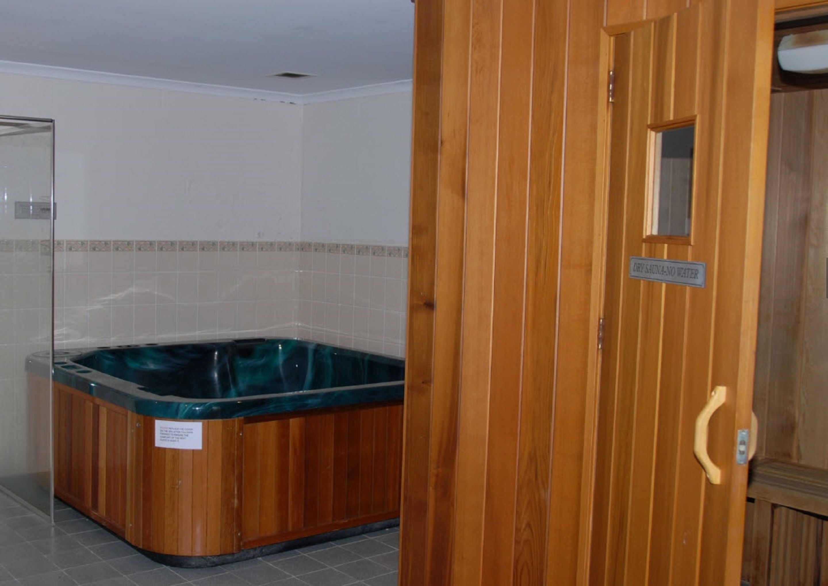 Una puerta de madera con un letrero que dice "SAUNA SECA - NO AGUA".