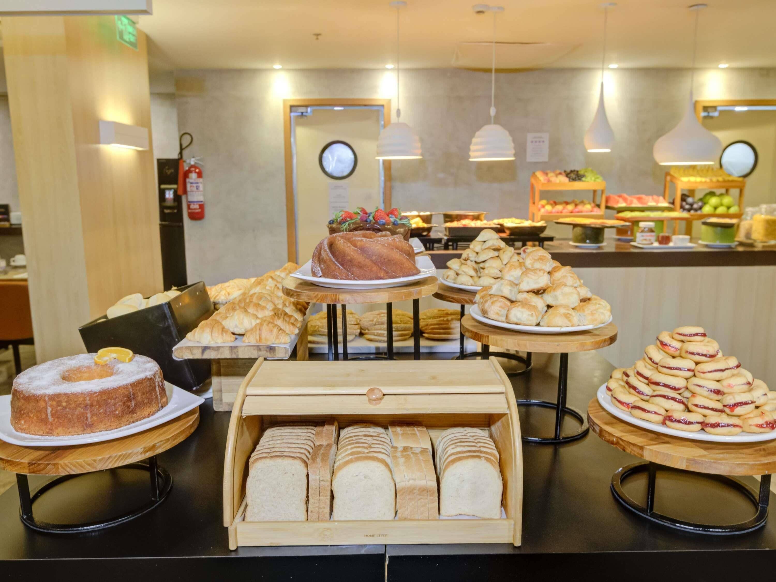 Una vitrina de panadería con diversas opciones de pan, pasteles y un pastel.