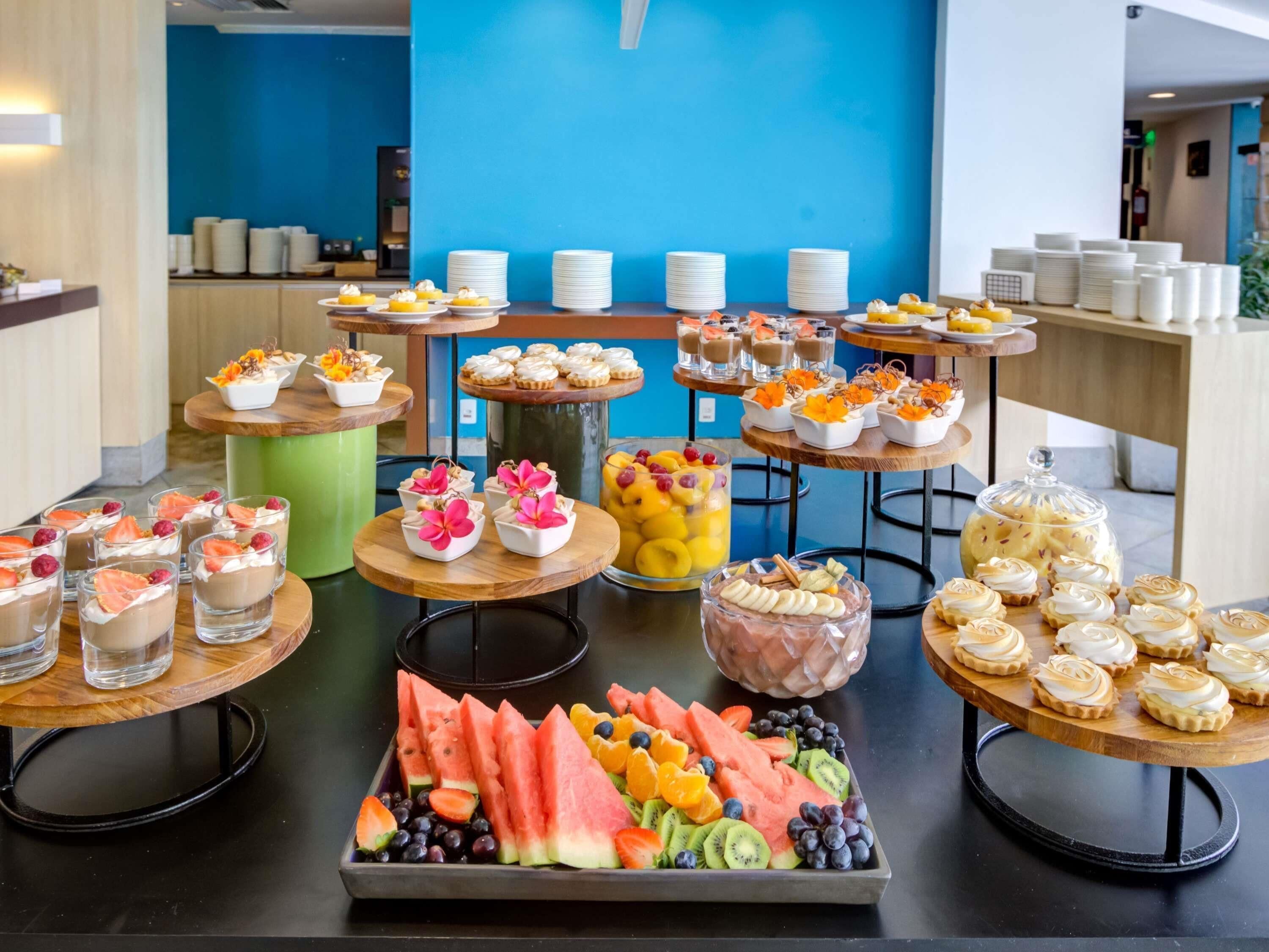 Un bufé con diversos postres y bandejas de fruta.