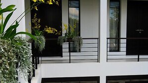 Een modern gebouw met balkons, grote ramen en plantenpotten.