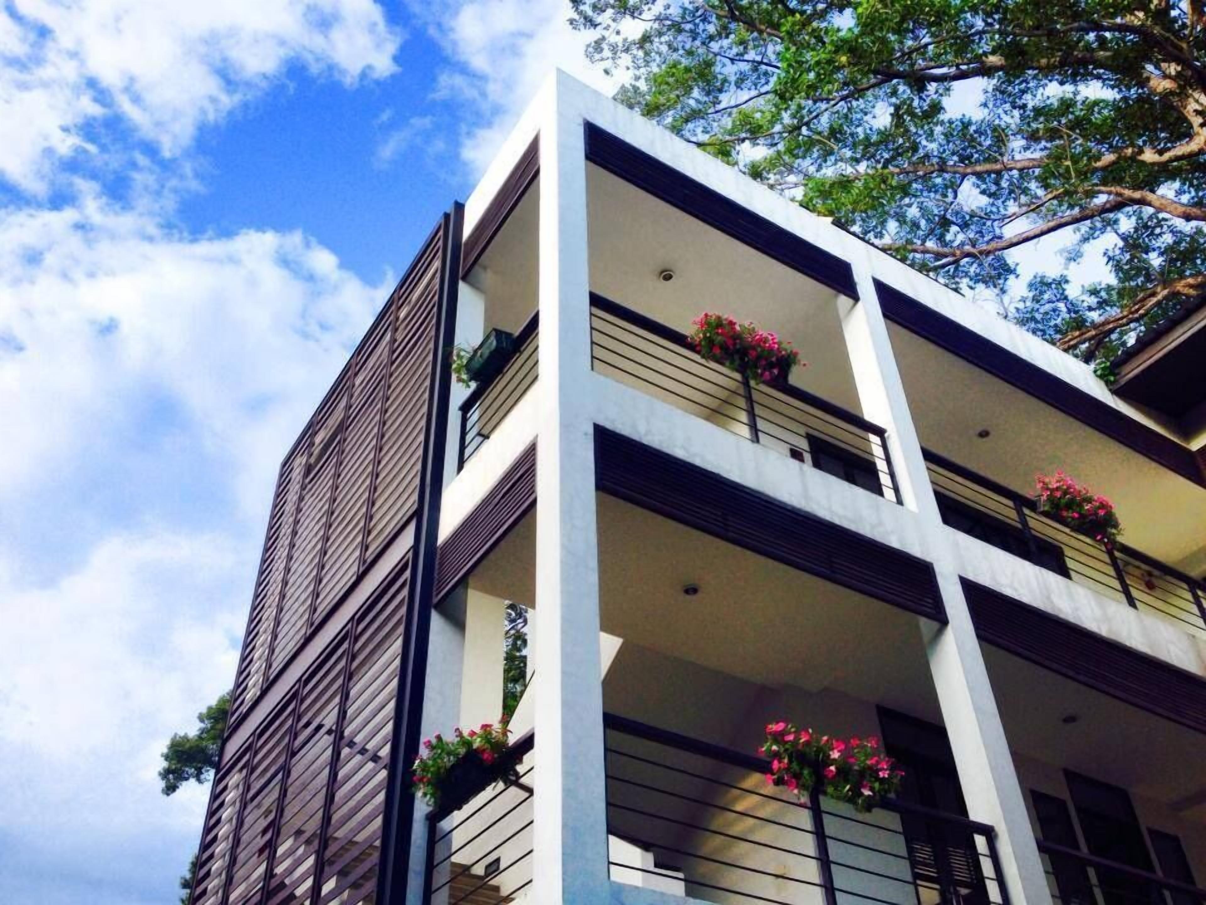 A multi-story building with balconies, each adorned with flower boxes.
