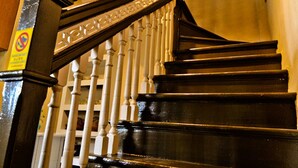 A wooden staircase with white balusters and a dark handrail, leading to an upper floor. - Dwell by Palanquinn (George Town)