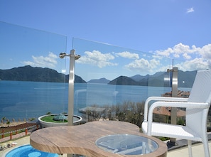 A balcony with a glass balustrade overlooking a body of water and mountains. - Green Nature Diamond Hotel (Marmaris)