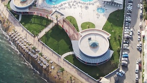 An aerial view of a resort with a central pool, multiple buildings, and a beach area. - Green Nature Diamond Hotel (Marmaris)