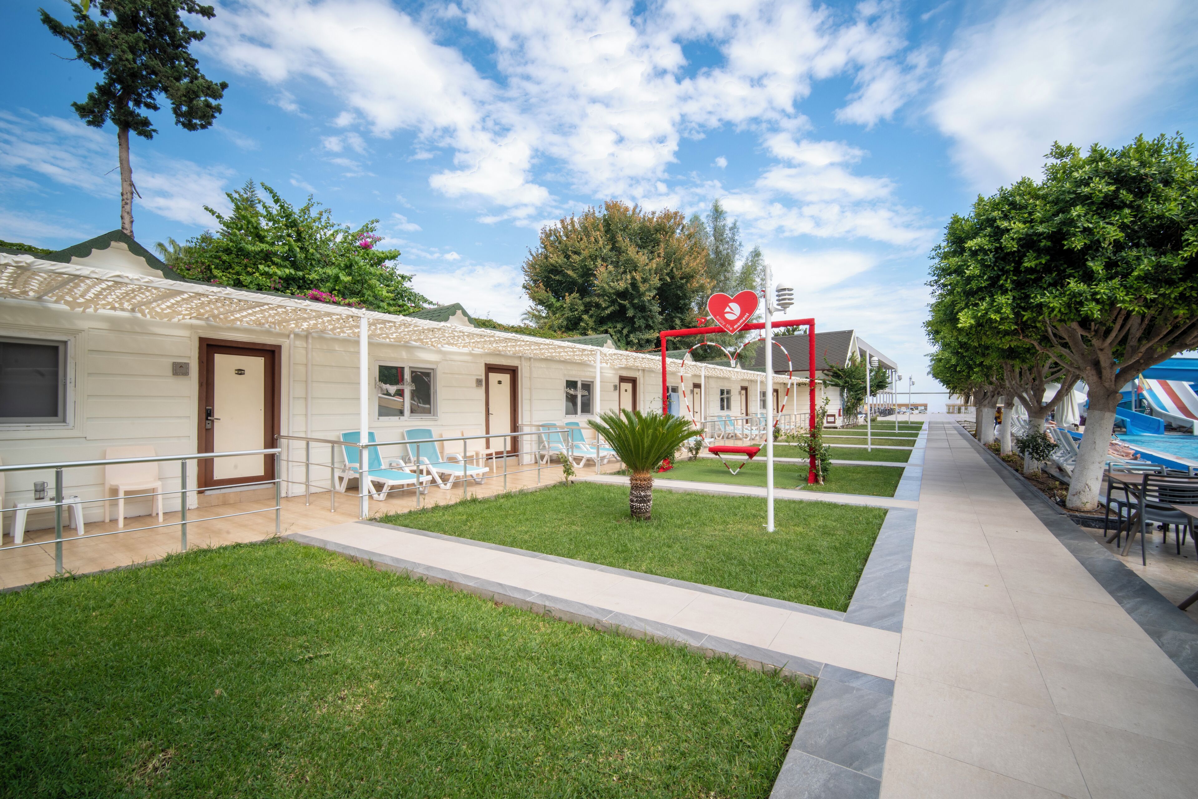 A hotel with a pool area, outdoor seating, and a well-maintained lawn.