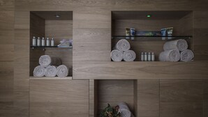Un baño con paneles de madera, repisas con artículos de tocador y toallas ordenadamente dobladas.
