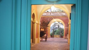 An interior corridor with a tiled floor and a carriage in the distance. - Palazzo Laura (Morciano di Leuca)