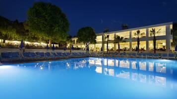 Una piscina al aire libre de temporada, sombrillas