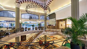 A spacious lobby with a central fountain, multiple seating areas, and a pool table.