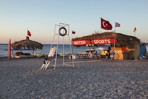 Ligstoelen aan het strand, parasols, strandlakens, beachvolleybal