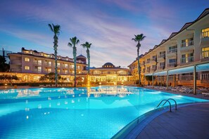 A hotel with a swimming pool, multiple balconies, and palm trees. - Fun Sun Smart Sultans Beach - All inclusive (Kemer)