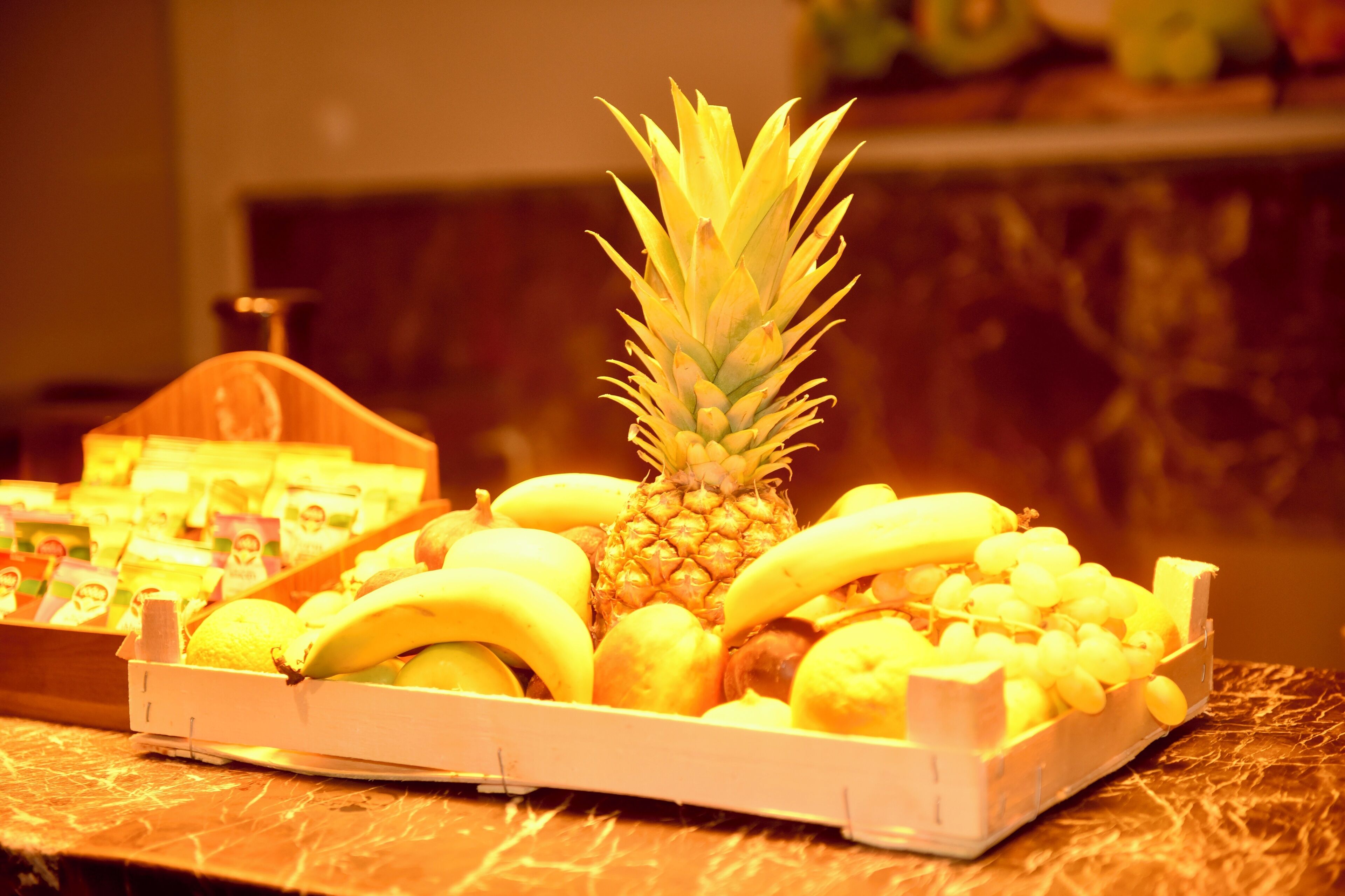 Eine Obstauslage mit Bananen, Zitronen und einer Ananas.