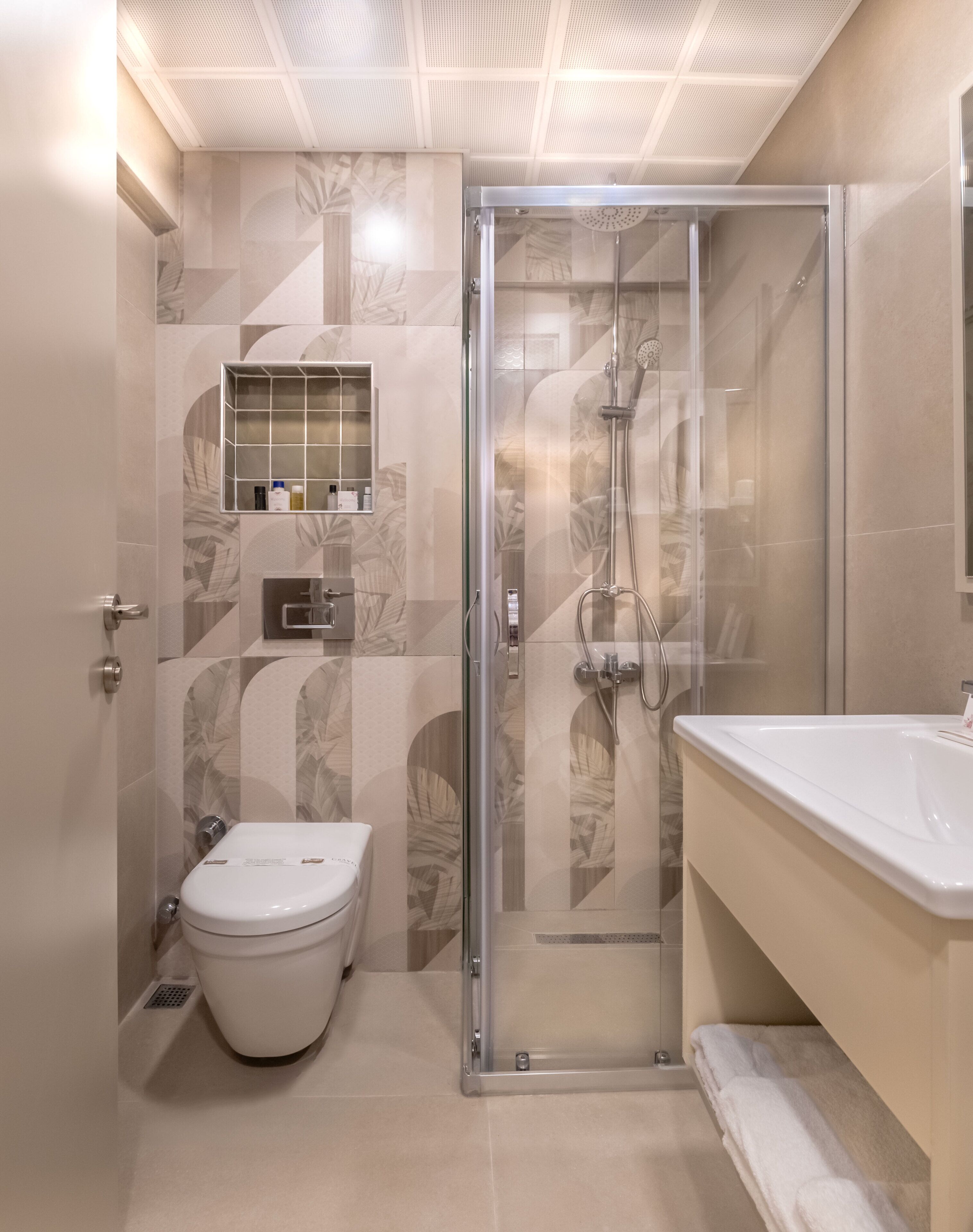 A modern bathroom with a glass-enclosed shower, a toilet, and a vanity with a sink.