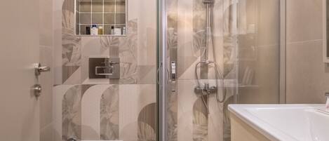 A modern bathroom with a glass-enclosed shower, a toilet, and a vanity with a sink.
