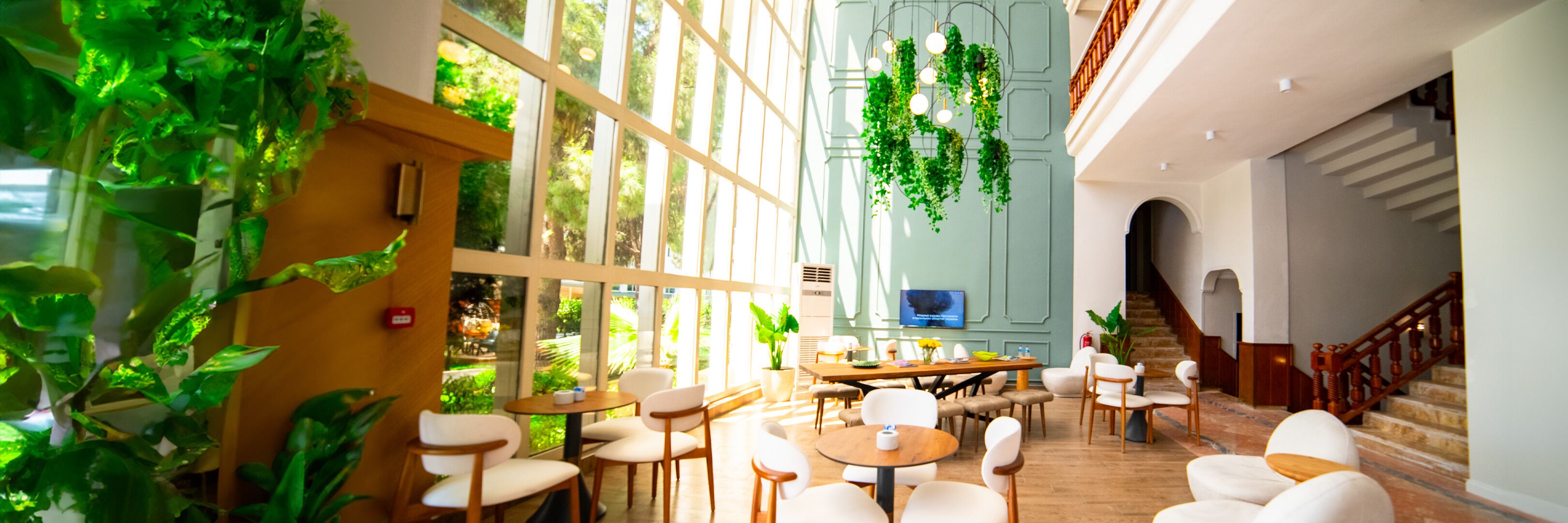 Amplio espacio interior con varias opciones de asiento, ventanas grandes y plantas colgantes.