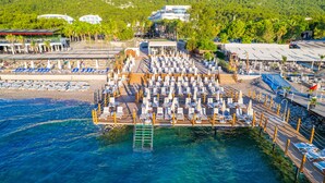 Un resort costero con una amplia zona de piscina, varias opciones de restauración y vistas al mar.