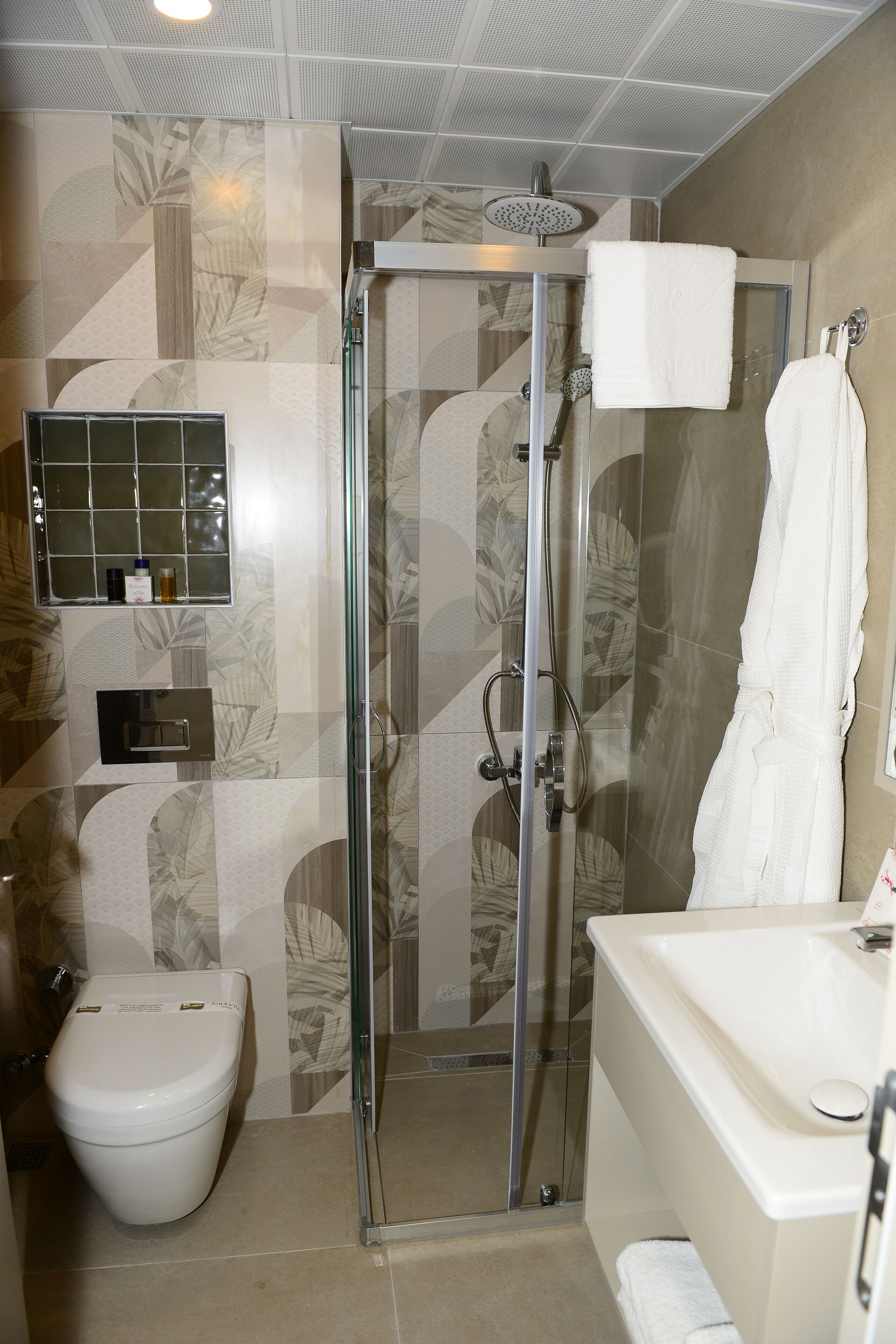 Un baño moderno con ducha envuelta en vidrio, inodoro y lavamanos.