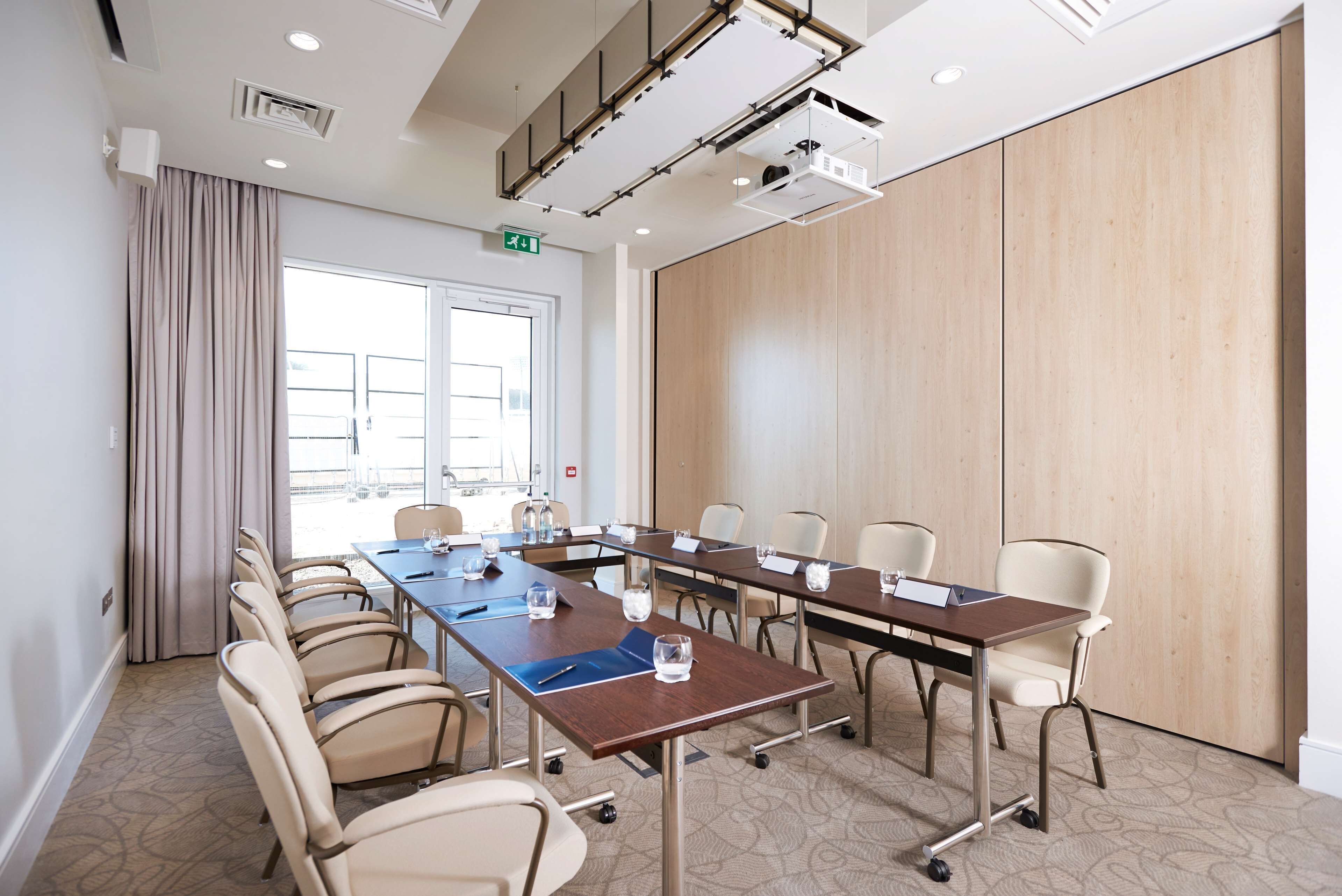 A conference room with a long table, chairs, and a large window.