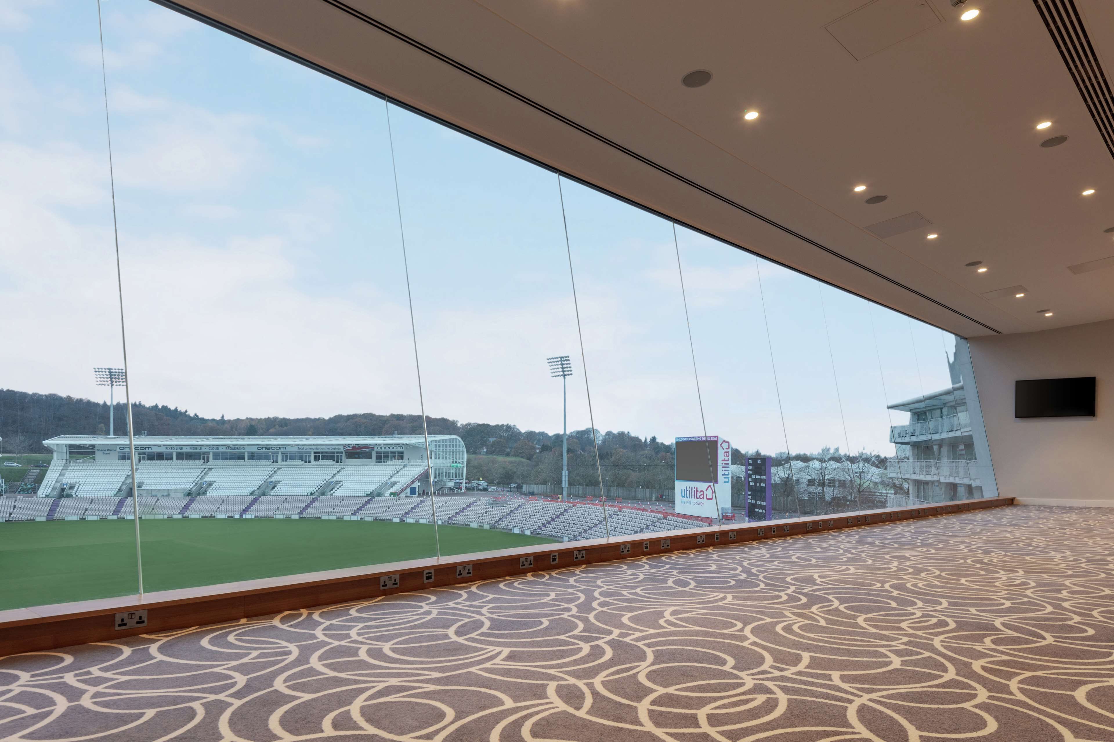 A stadium view from inside a building with a patterned carpet and a large window.